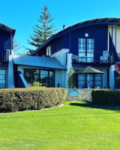 a blue house with a lawn in front of it at Stunning Ocean View Villa 2 Dunsborough in Dunsborough