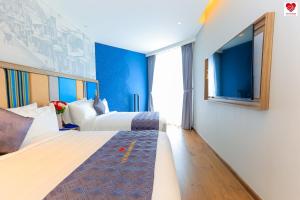 ein Hotelzimmer mit 2 Betten und einem großen Fenster in der Unterkunft Holiday Apartment - Apec Mandala Wyndham Mũi Né in Ấp Thiẹn Ái