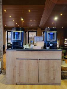 - un bar avec deux machines à café en haut dans l'établissement Hotel La Résidence Manoir De La Salamandre, à Étretat