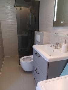 a white bathroom with a toilet and a sink at Caveromane 2 in Pula