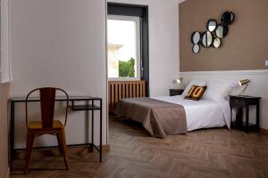sypialnia z łóżkiem, krzesłem i oknem w obiekcie L'Aparté w mieście Salles