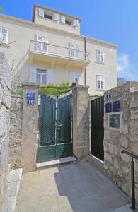 un edificio con una puerta verde delante de él en Vicina Summer Apartments, en Dubrovnik