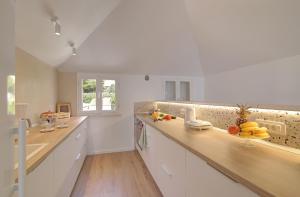 - une cuisine avec des placards blancs et des comptoirs en bois dans l'établissement Vicina Summer Apartments, à Dubrovnik