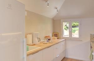 a kitchen with white cabinets and a window at Vicina Summer Apartments in Dubrovnik
