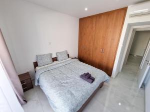 ein Schlafzimmer mit einem Bett mit einem lila Handtuch darauf in der Unterkunft Sea Bay Apartment in Larnaka