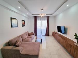 a living room with a couch and a tv at Sea Bay Apartment in Larnaka