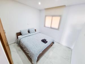 ein Schlafzimmer mit einem Bett in einem weißen Zimmer in der Unterkunft Sea Bay Apartment in Larnaka