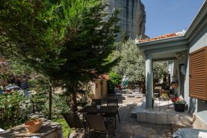 eine Terrasse eines Hauses mit einem Tisch und Stühlen in der Unterkunft Rina's House in Kalambaka