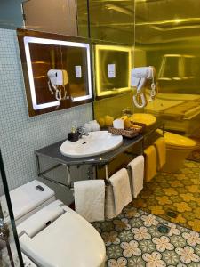 ein Badezimmer mit einem Waschbecken, einem WC und einem Spiegel in der Unterkunft Nhat Quy Hotel in Tây Ninh