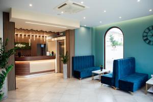 a waiting room with blue chairs and a counter at Hotel St. Giorgio in Castel San Giorgio