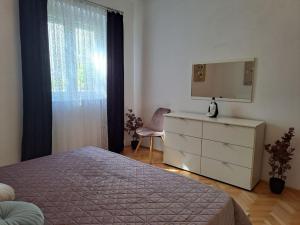 a bedroom with a bed and a dresser and a mirror at Apartment Rita in Dramalj