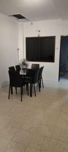 a dining room with a black table and chairs at NTC Homestay at Parit Buntar in Parit Buntar