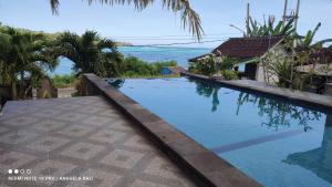 a swimming pool with a view of the ocean at Kusuma Abiakta Sea Side Lembongan in Nusa Lembongan
