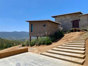 una casa en una colina con escaleras delante en Prajna Valle de Guadalupe, en Valle de Guadalupe