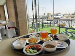 a tray filled with food on a table with drinks at فندق اليمامه الفندقية in Al Nairyah +15 photos