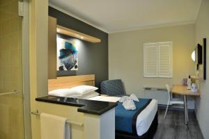 Pokój hotelowy z łóżkiem i biurkiem w obiekcie Road Lodge Randburg w mieście Johannesburg