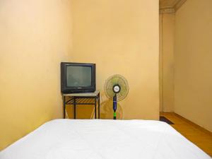 名古屋的住宿－SPOT ON 92569 Anto Homestay Syariah，一间卧室配有一张床、一台电视和风扇