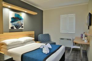 um quarto com uma cama com um bicho de peluche em Road Lodge Randburg em Joanesburgo