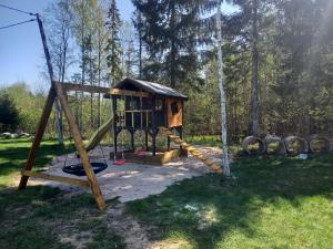 un parque infantil con una casa en el árbol y un columpio en Tuimõisa Puhketalu, en Tuimõisa