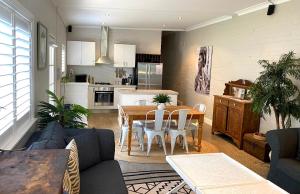 a living room with a table and a kitchen at The Edward Townhouse 157 - Steps to Town in Orange