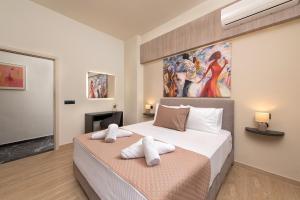 a bedroom with two beds and a painting on the wall at Adelais Luxury City Apartment Rhodes in Rhodes Town