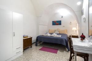 a bedroom with a bed and a table in a room at Chiarina rooms in Polignano a Mare