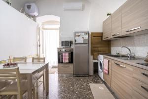 uma cozinha com um frigorífico de aço inoxidável e uma mesa em Chiarina rooms em Polignano a Mare