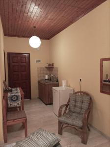 - un salon avec une chaise et un réfrigérateur dans l'établissement Spiti Mitsis, à Arillas