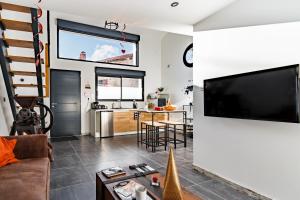 uma sala de estar com uma grande televisão de ecrã plano na parede em Love Loft Spa em Ambronay