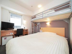 a bedroom with a bed and a desk and a bunk bed at Super Hotel Kokuraeki Minamiguchi in Kitakyushu