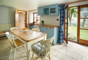 een keuken met een houten tafel en stoelen bij Fron Cottage in Llangynog