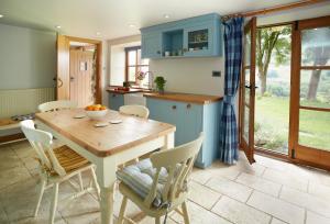 a kitchen with a wooden table and chairs at Fron Cottage in Llangynog