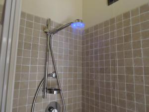 a shower with a blue light in a bathroom at La casa di Marco e Lorella in Fratta Todina