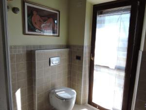 uma casa de banho com WC e uma fotografia na parede em La casa di Marco e Lorella em Fratta Todina