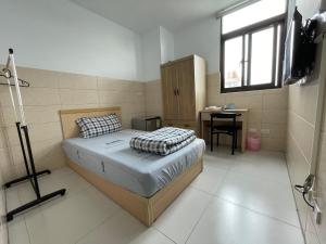 una camera da letto con un letto e una scrivania di HeMei Homestay a Ho-mei