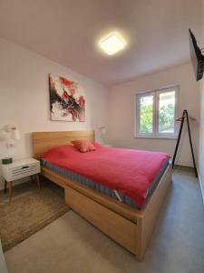 a bedroom with a large bed with a red blanket at Vila Beleca Krk - Apartments Rest & Sea in Krk