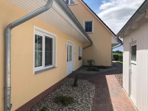 奥斯科卡爾斯哈根的住宿－Ferienwohnung Dominik，前面有砖砌走道的黄色房子