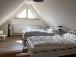 a attic bedroom with two beds and a window at Ferienwohnung Dominik in Ostseebad Karlshagen