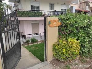 un cancello aperto per una casa con un cespuglio di Olivia Studios - Melina's home near the sea a Agia Triada