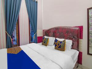 Schlafzimmer mit einem großen Bett und blauen Vorhängen in der Unterkunft SPOT ON 92570 Putri Guest House Syariah in Pekanbaru