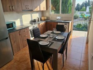 una cocina con mesa con 4 sillas y una cocina con en NTORAS Holiday Home, en Pafos