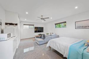 a white bedroom with a bed and a couch at Scarborough Beach Break Holidays - Unit 5 in Scarborough