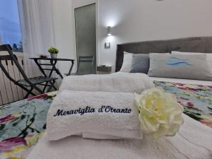 a bedroom with two beds with towels and a flower at Meraviglia d'Otranto in Otranto