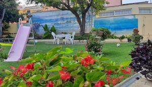un cortile con scivolo rosa e parco giochi di Casa Vacanze Arba Girasole a Girasole
