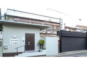 ein weißes Gebäude mit einem Tor und einer Garage in der Unterkunft Kyoto - Hotel / Vacation STAY 36511 in Kyoto