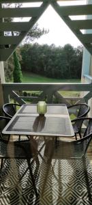 a table and chairs on a balcony with a view at Appart Cosy Green, Océan, Golf, Piscine, Wifi in Moliets-et-Maa