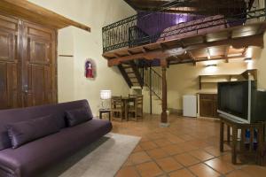 a living room with a purple couch and a kitchen at Hotel La Pérgola in Granada