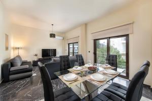 a dining room and living room with a table and chairs at Adelais Luxury City Apartment Rhodes in Rhodes Town