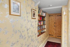 a hallway with blue and white wallpaper and a book shelf at Bellamarsh Farm B&B in Newton Abbot