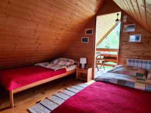 a bedroom with two beds in a wooden cabin at Domki Pod Horbem in Polańczyk